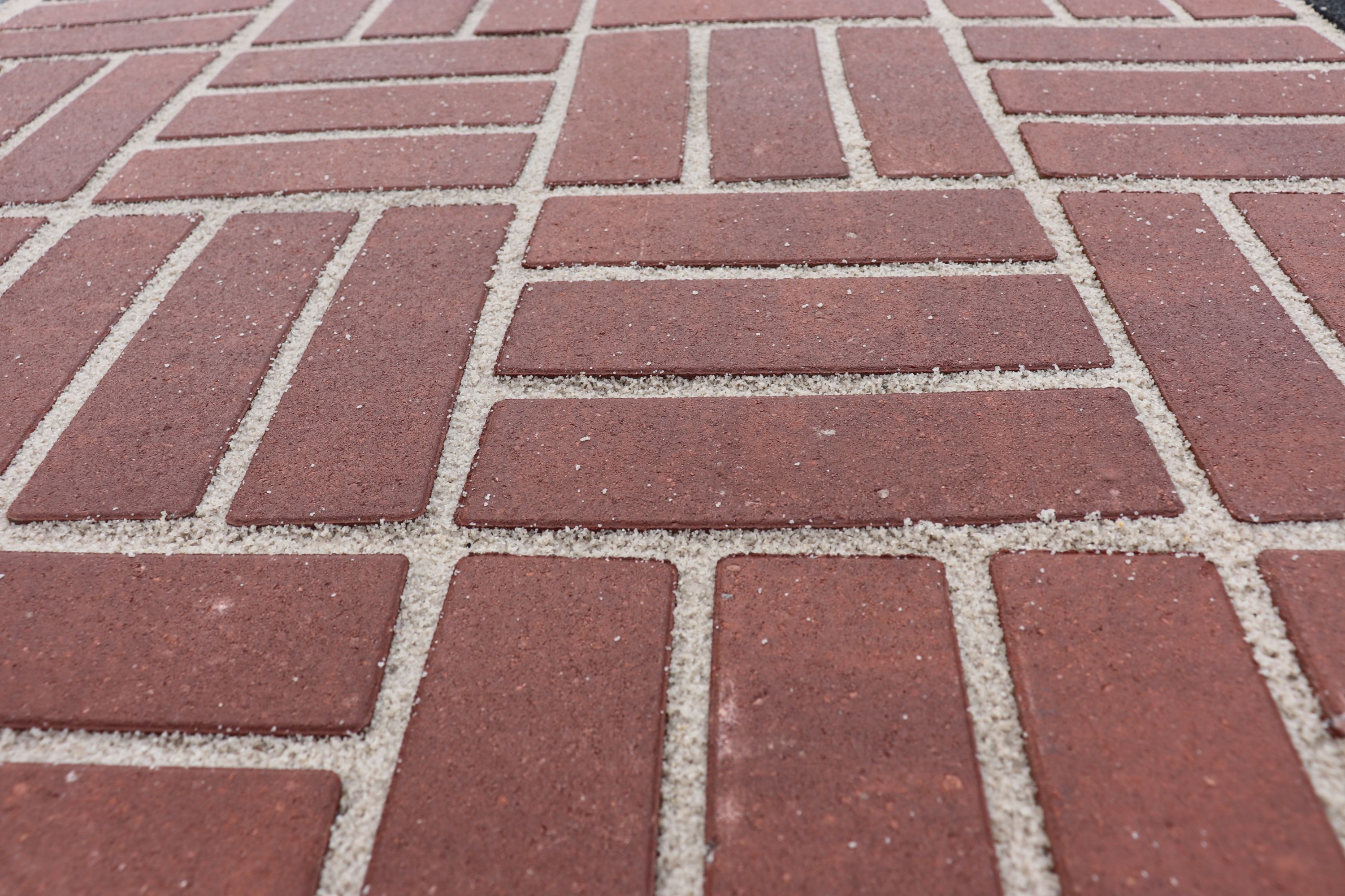 close up waterdoorlatende verharding, terracotta langwerpige klinkers, met een dikke waterdoorlatende voeg.